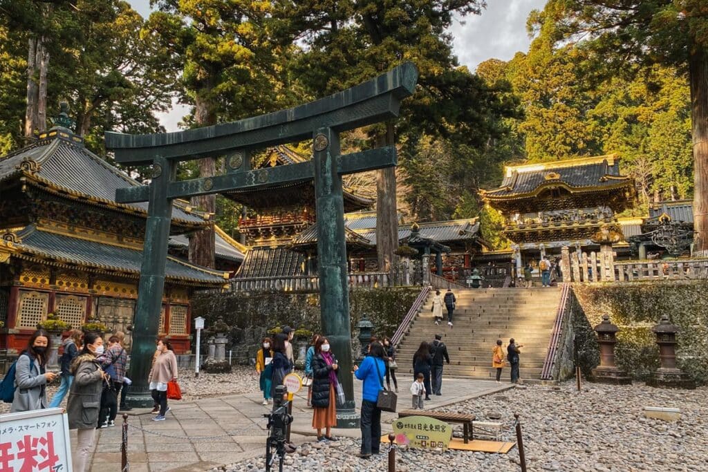 people standing around the torii gate at the entrance to Toshogu shrine, Nikko