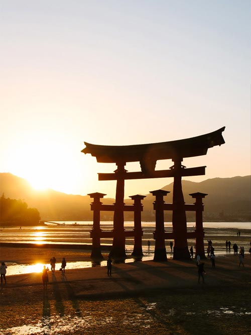 silhouette of the grand torii gate of itsukushima shrine on miyajima at sunset