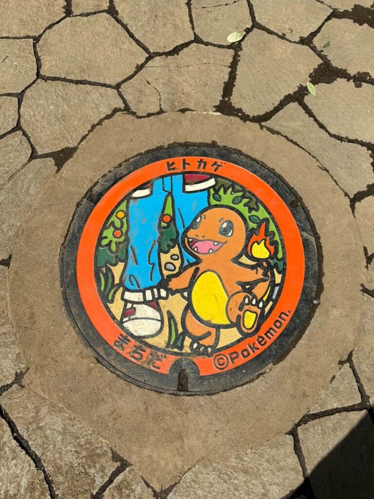 charmander pokemon manhole cover in bright sun in machida tokyo