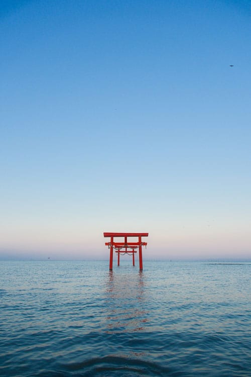 floating torii gates of ouo shrine in nagasaki prefecture on a clear day with blue skies