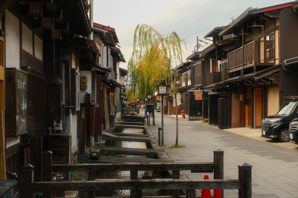 street in hida furukawa with canals, traditional wooden houses and willow trees