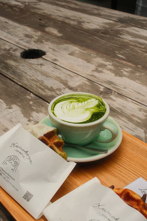 matcha latte and waffle from kanokoya cafe in hida-furukawa on a wooden table