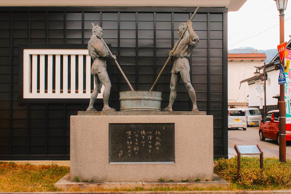 statue of two men stirring sake in hida furukawa