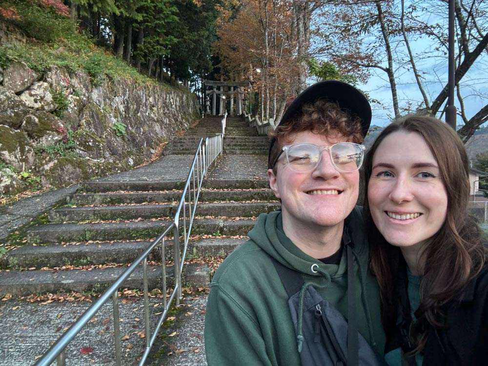nele and richard standing in front of the stairs towards shrine in hida furukawa featured in your name movie